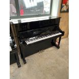 Yamaha (c2000) A Model YU1 upright piano in a traditional bright ebonised case.