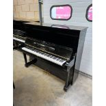 Yamaha (c1969) An upright piano in a bright ebonised case.