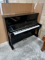 Yamaha (c1973) A Model U1 upright piano in a bright ebonised case.