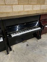 Yamaha (c1977) A Model U1 upright piano in a traditional bright ebonised case; together with a