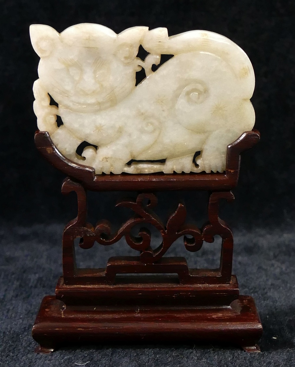 A Chinese carved stone panel in the form of a cat, 6cm long, on hardwood stand, and a pierced and