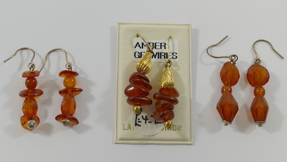 A selection of amber jewellery comprised of a butterscotch amber pendant, 2.6cm long, a larger - Image 2 of 3