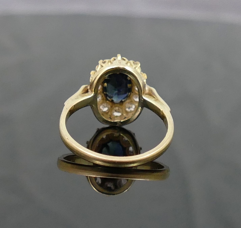 A sapphire and diamond oval cluster ring, the oval mixed-cut sapphire approximately 1 carat,  claw - Image 4 of 4