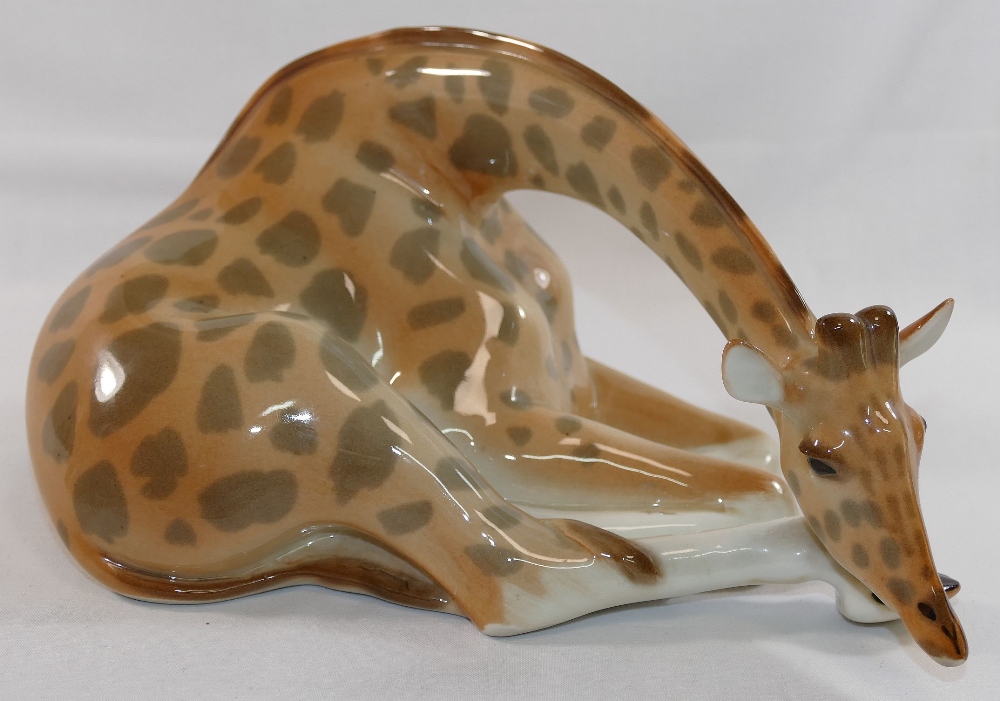 A Lomonosov USSR porcelain giraffe in seated position, 26cm long, and a Lladro porcelain geese