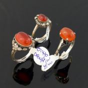 A selection of carnelian jewellery comprised of a large oval brooch, 6cm wide, a smaller brooch, a