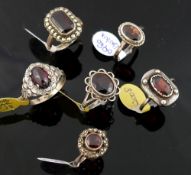 A collection of 12 red garnet set rings, including some set with marcasite, most stamped 'silver' or