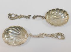 A pair of late Victorian silver serving spoons with shell-shaped bowls and pierced and cast acanthus