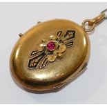 A 19th century French gold oval locket, set with single red stone within inlaid black enamel