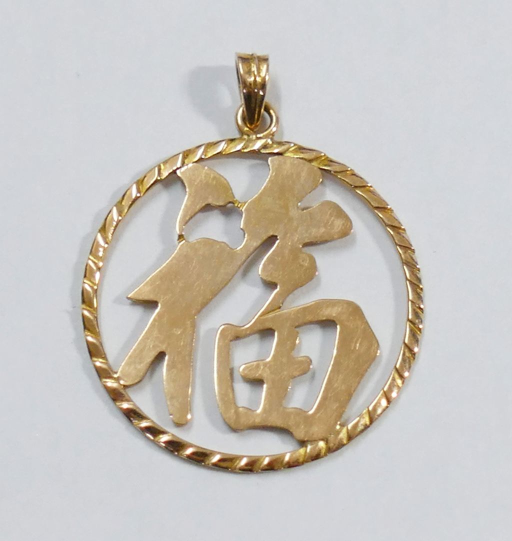 A Chinese yellow metal circular 'Fu' pendant, the Chinese symbol for good fortune, indistinctly
