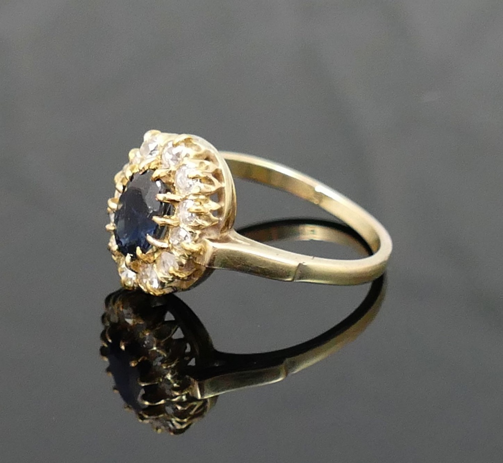 A sapphire and diamond oval cluster ring, the oval mixed-cut sapphire approximately 1 carat,  claw - Image 2 of 4