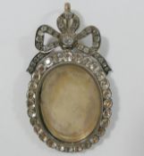 A large 19th century paste set silver locket, with hinged back and bow surmount, 7.5cm long x 4.