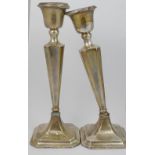 A pair of silver candlesticks with weighted bases, a pair of small silver trumpet-shaped vases, also