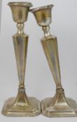 A pair of silver candlesticks with weighted bases, a pair of small silver trumpet-shaped vases, also