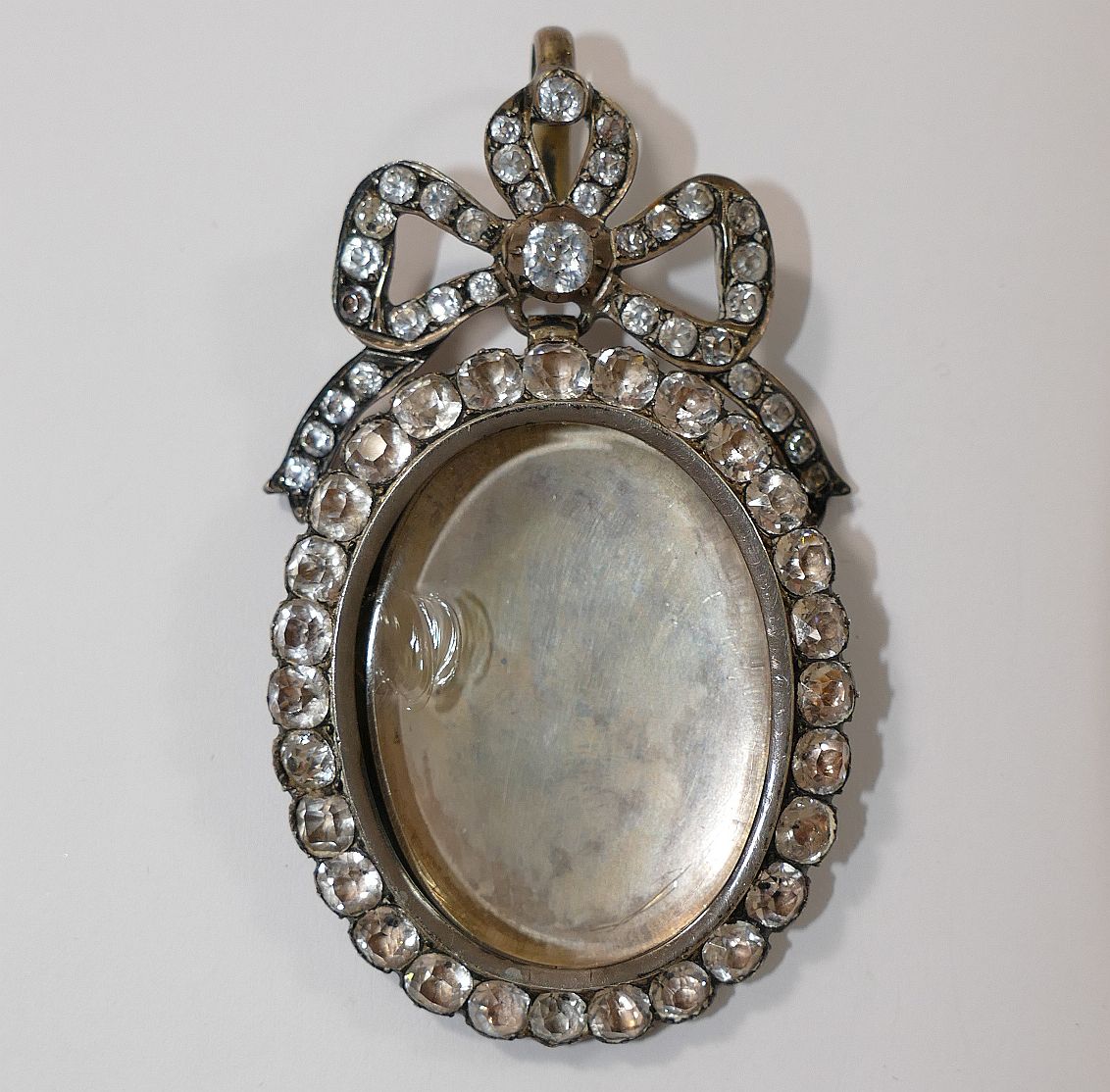 A large 19th century paste set silver locket, with hinged back and bow surmount, 7.5cm long x 4. - Image 2 of 3