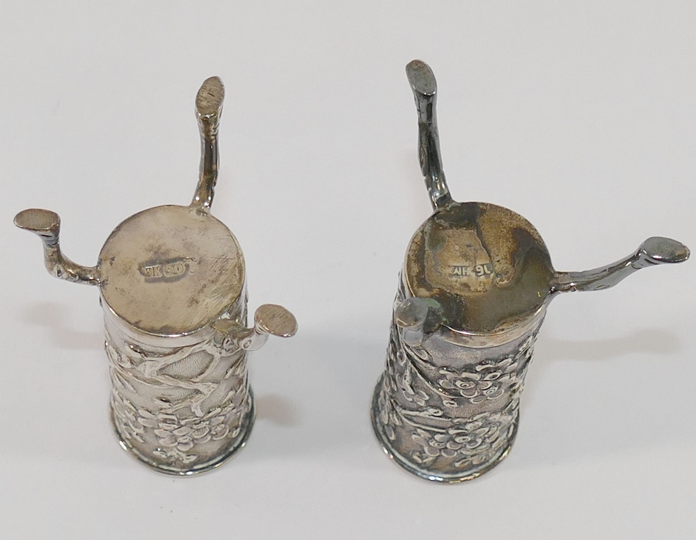 A pair of small Chinese silver cylindrical vases, each raised on three legs and decorated with - Image 2 of 2