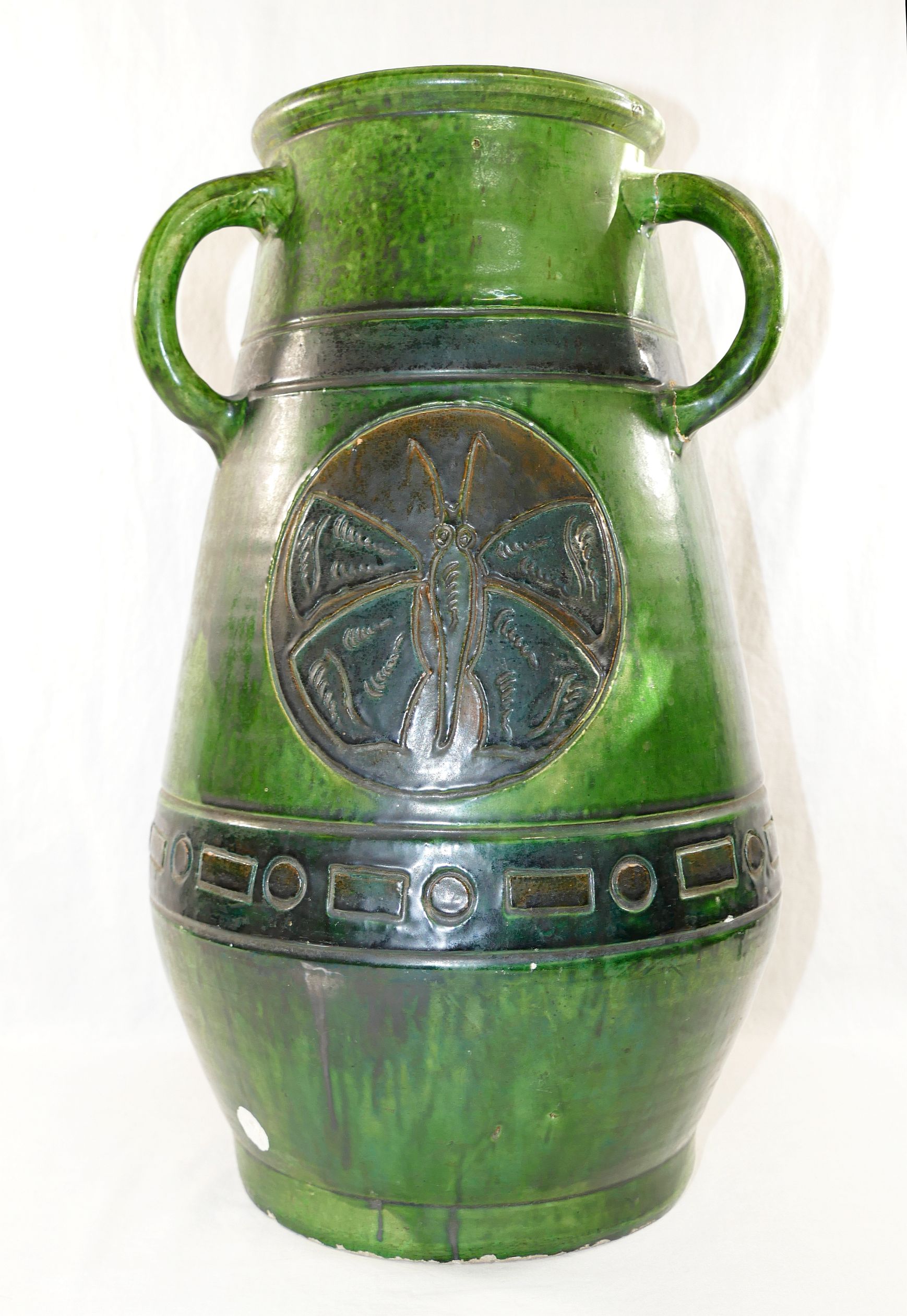 A large Studio Pottery green glazed three handled vase, decorated with incised circular panels of