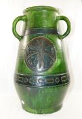 A large Studio Pottery green glazed three handled vase, decorated with incised circular panels of