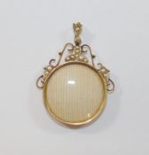 A gold and half pearl set glazed circular keepsake pendant, indistinctly marked to the edge of the