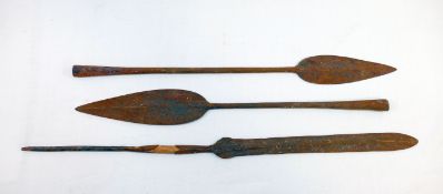 Three African iron spear heads, the longest 50cm, and a carved tribal wooden ceremonial paddle, with