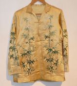 A 20th century Chinese embroidered jacket, the golden fabric embroidered in green with bamboo