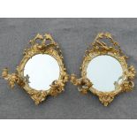 A pair of 19th century circular girandole mirrors, the twin branches each with two lights, the