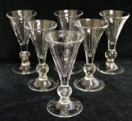 A set of six wine glasses with conical bowls, the knopped stems containing a single tear air bubble,