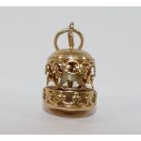 A yellow metal four-section puzzle ring, finger size V1/2, a yellow metal merry-go-round charm and a