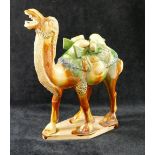 A 20th century Chinese Tang dynasty style glazed pottery figure of a caparisoned camel, on lozenge-
