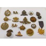 A collection of military cap badges including Royal Welsh Fusiliers, Manchester Regiment and Royal