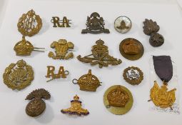 A collection of military cap badges including Royal Welsh Fusiliers, Manchester Regiment and Royal