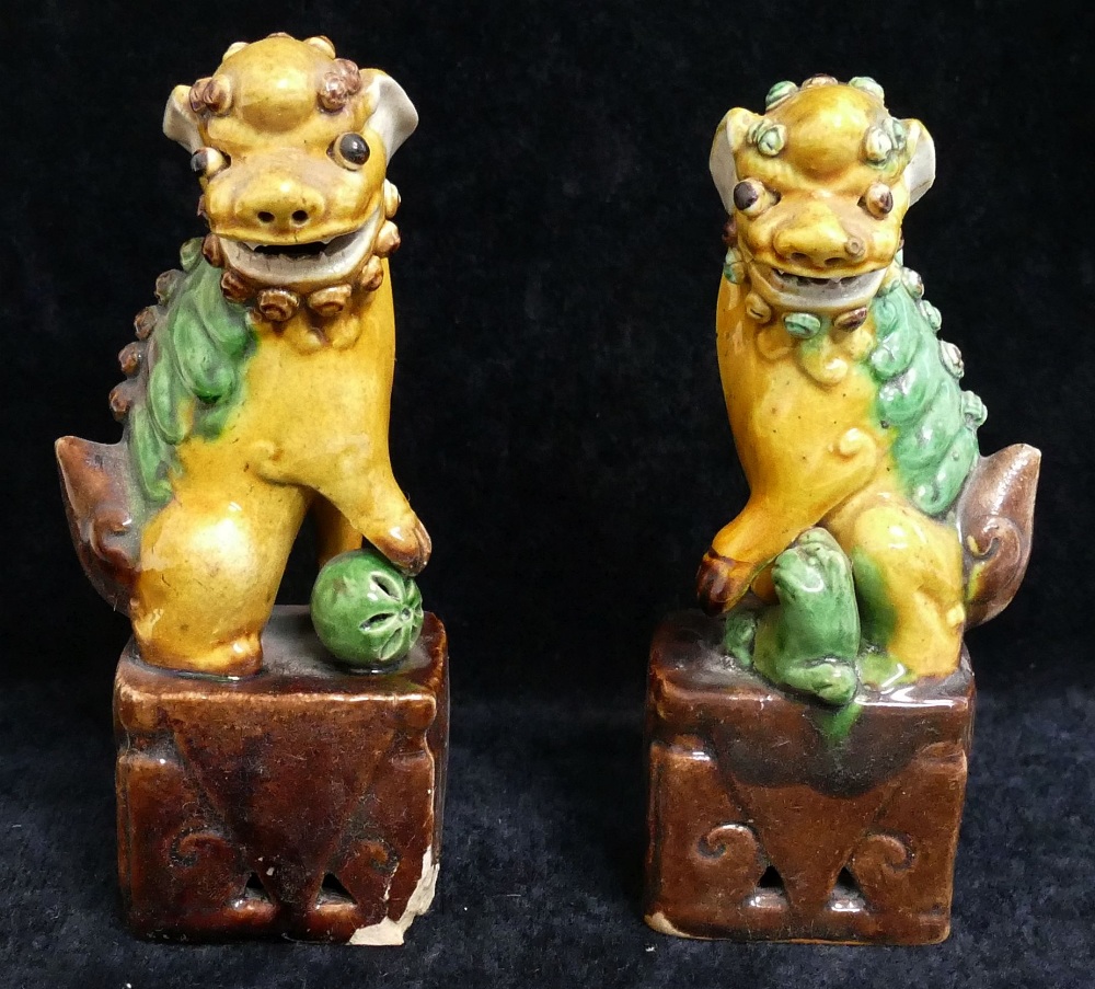 Two small Chinese pottery figures of temple dogs, a small carved figure of a deity, other carved