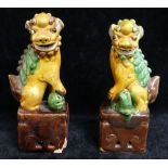 Two small Chinese pottery figures of temple dogs, a small carved figure of a deity, other carved