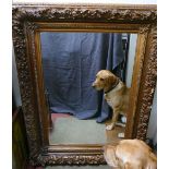 A large rectangular gilt framed wall mirror with heavily moulded frame and bevelled glass plate, the