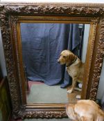 A large rectangular gilt framed wall mirror with heavily moulded frame and bevelled glass plate, the