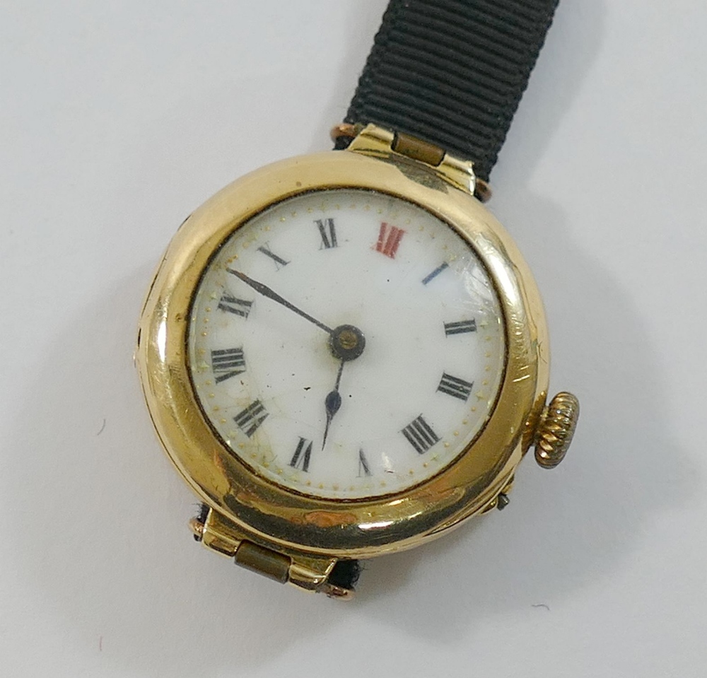 A ladies 15 carat gold cased wrist watch, with white enamel dial, ribbon strap with clasp stamped '