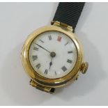 A ladies 15 carat gold cased wrist watch, with white enamel dial, ribbon strap with clasp stamped '