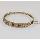 A late19th/early 20th century possibly French sapphire and diamond set hinged bangle, the four old-