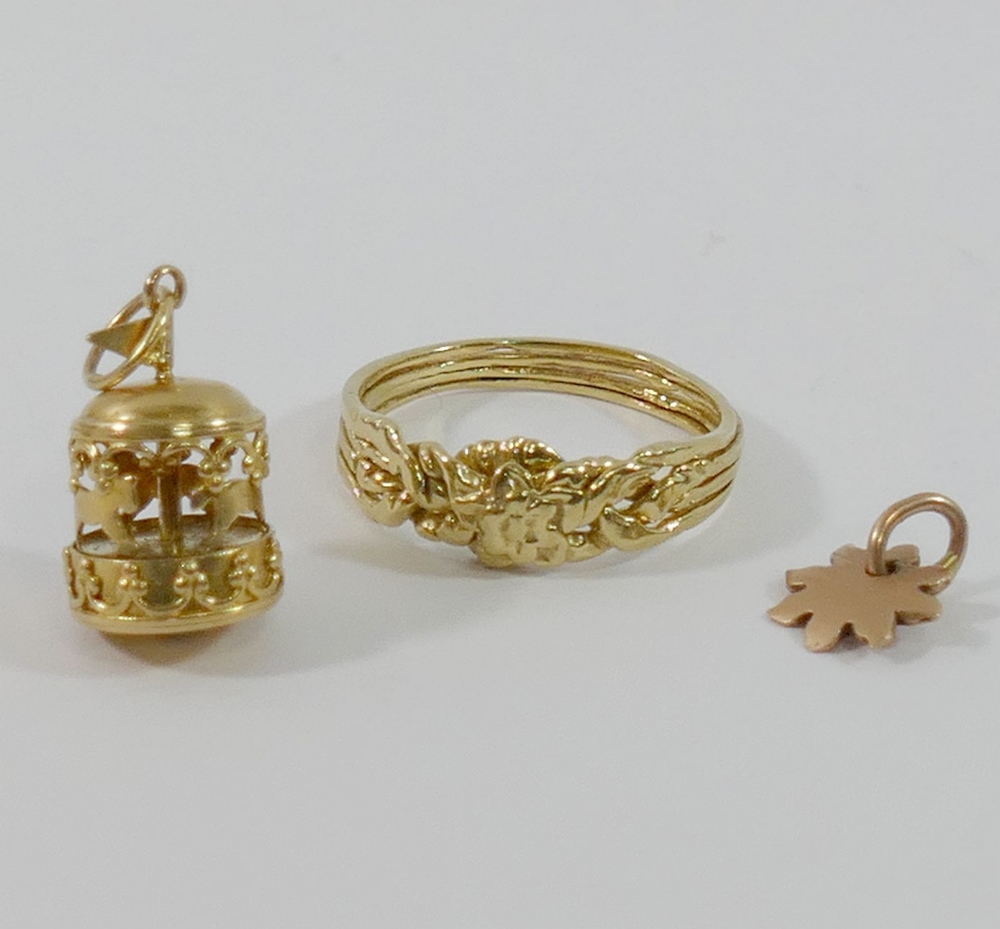 A yellow metal four-section puzzle ring, finger size V1/2, a yellow metal merry-go-round charm and a - Image 3 of 3