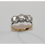 A 9 carat gold diamond simulant three-stone ring, the stones claw-set in white to a yellow shank,