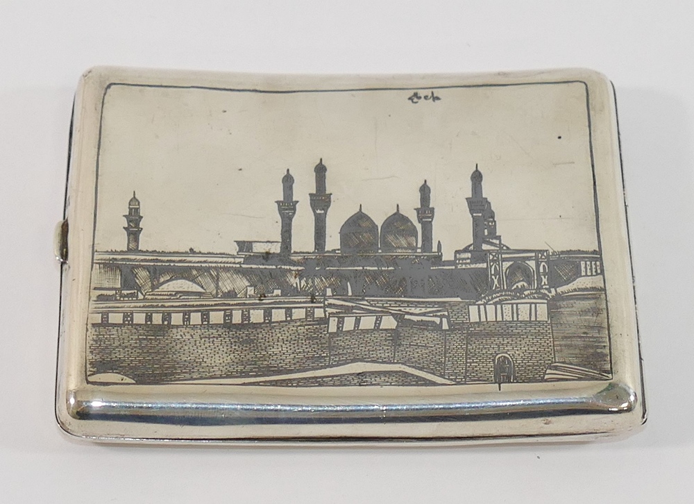 An Iraqi silver and niello cigarette case decorated with a camel and traders to one side and a