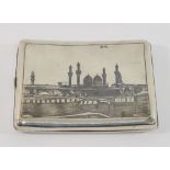 An Iraqi silver and niello cigarette case decorated with a camel and traders to one side and a