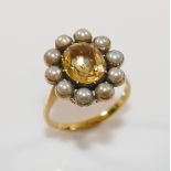 A 19th century gold, yellow topaz and half pearl oval cluster ring, the oval mixed cut topaz in