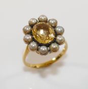 A 19th century gold, yellow topaz and half pearl oval cluster ring, the oval mixed cut topaz in