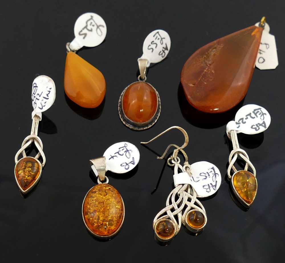 A selection of amber jewellery comprised of a butterscotch amber pendant, 2.6cm long, a larger