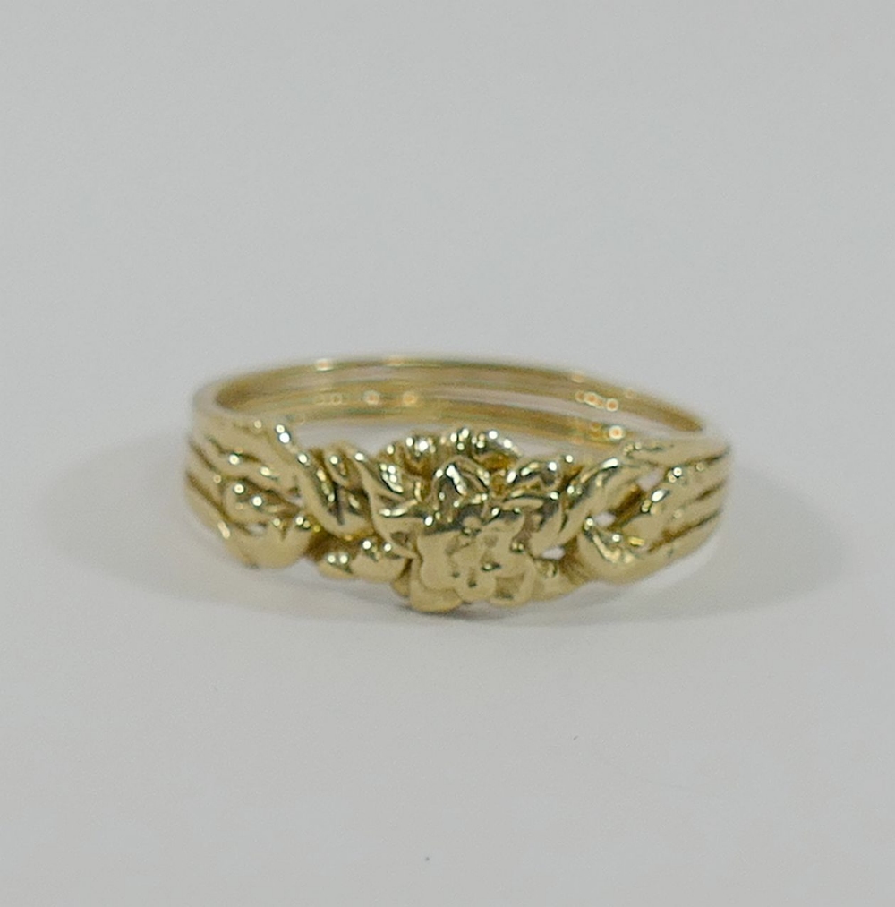 A yellow metal four-section puzzle ring, finger size V1/2, a yellow metal merry-go-round charm and a - Image 2 of 3