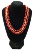 Two strings of individually knotted red coral bead necklaces, with a pair of matching drop