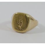 A yellow metal signet ring, intaglio carved with the crest of the palm of a hand, finger size H 1/2,