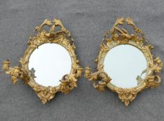 A pair of 19th century circular girandole mirrors, the twin branches each with two lights, the