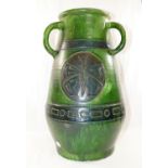 A large Studio Pottery green glazed three handled vase, decorated with incised circular panels of
