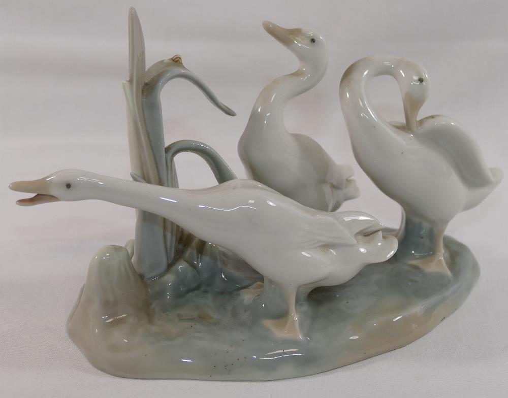 A Lomonosov USSR porcelain giraffe in seated position, 26cm long, and a Lladro porcelain geese